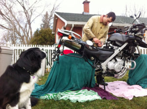 working on servicing motorcycle in backyard