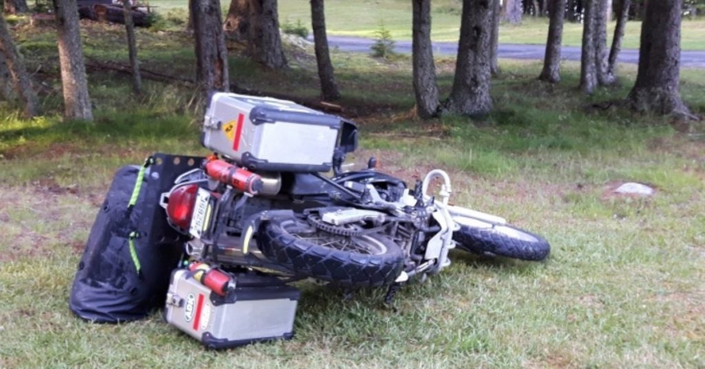 Motorcycle laying on a lawn.